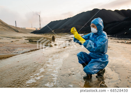 Contemporary female ecologist or researcher making experiments in toxic area 68528430
