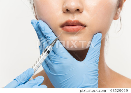 Apply syringe to woman's lips Apply syringe to woman's lips 68529039