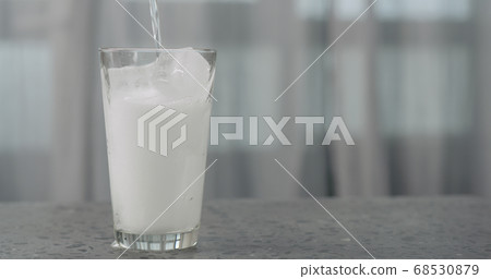 pour soda in glass with ice cubes on concrete countertop pour soda in glass with ice cubes on concrete countertop 68530879