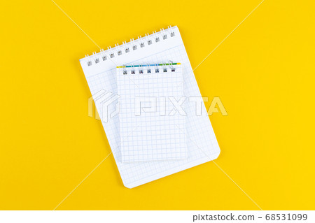 Open notebook on bright yellow paper background Open notebook on bright yellow paper background 68531099