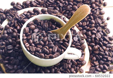 High angle view coffee beans spill out from coffee High angle view coffee beans spill out from coffee 68532022