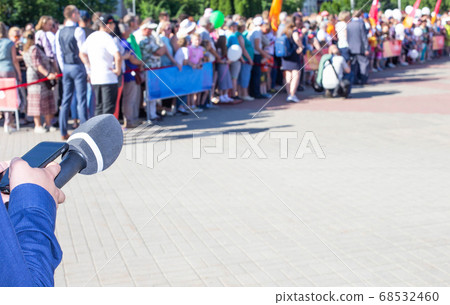 hands of a reporter with a microphone on the background of a crowd of people. Interview and news concept, Copy space for text 68532460