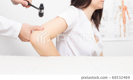 Doctor neurologist checks triceps reflex in a girl patient. Examination by a neurologist in the office, medical, nervous system Doctor neurologist checks triceps reflex in a girl patient. Examination by a neurologist in the office, medical, nervous system 68532469