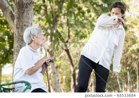Senior woman with fever,cough and sneezing without protection,elderly patient should find a mask to prevent the spread of Covid-19 and protect others,risk symptoms of Coronavirus,influenza pandemic 68533684