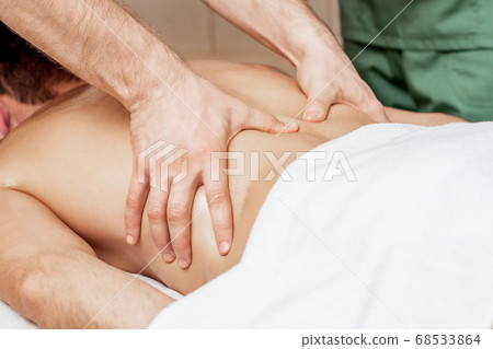 Back massage on back of man. Back massage on back of man. 68533864