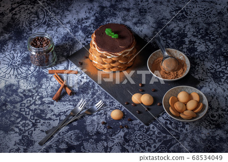 Homemade round tiramisu cake with cup of coffee and biscuits 68534049