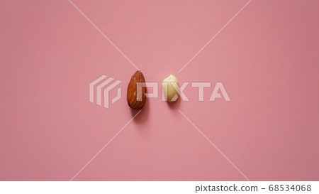 Almonds and peanuts on a pink background Almonds and peanuts on a pink background 68534068