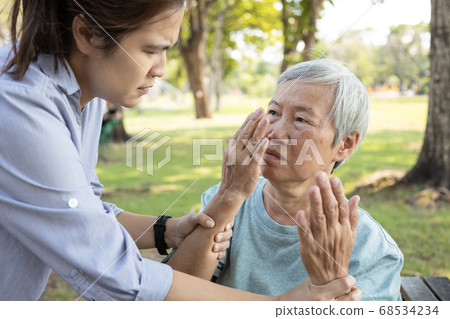 Asian daughter is forbidding her senior mother from touching the face,dirty hands risk of bacteria or germs into the mouth and nose,preventing Coronavirus infection,protection outbreak of the Covid-19 68534234