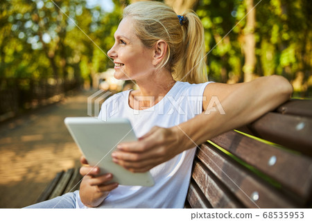 Beautiful woman using tablet computer on the street 68535953