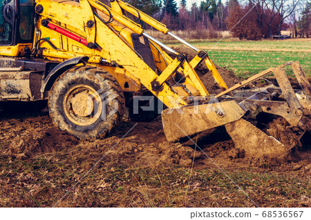 The excavator is digging the ground for the The excavator is digging the ground for the 68536567