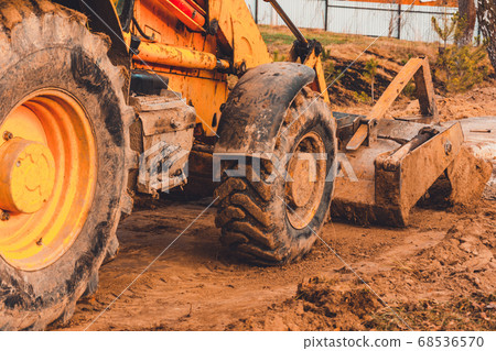 The excavator in the countryside moves the 68536570