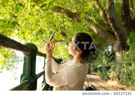 Japanese woman in her 50s taking landscape photos with her smartphone while taking a walk while traveling abroad Japanese woman in her 50s taking landscape photos with her smartphone while taking a walk while traveling abroad 68537192
