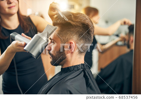 Close up of female hand holding hairdryer Close up of female hand holding hairdryer 68537456