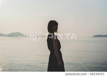 在夕陽的海中的女人 68539425