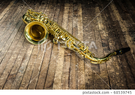 yellow saxophone musical instrument lies on a 68539745