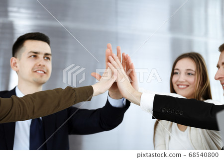 Business people group showing teamwork and joining hands or giving five in modern office. Unknown businessman and women making circle with their hands Business people group showing teamwork and joining hands or giving five in modern office. Unknown businessman and women making circle with their hands 68540800