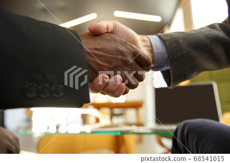 Close up of businessmen shaking hands in conference room Close up of businessmen shaking hands in conference room 68541015