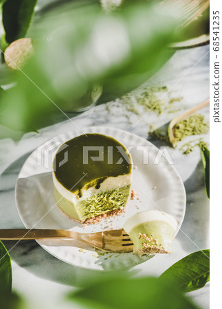 Green matcha cheesecake over grey marble 68541235