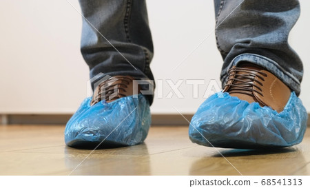 Man goes in shoe covers to the doctor Man goes in shoe covers to the doctor 68541313