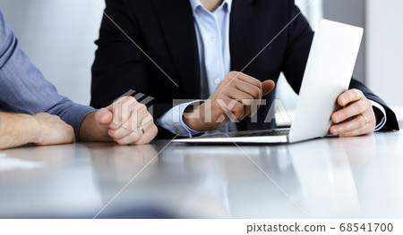 Business people using laptop computer while working together at the desk in modern office. Unknown businessman or male entrepreneur with colleague at workplace. Teamwork and partnership concept Business people using laptop computer while working together at the desk in modern office. Unknown businessman or male entrepreneur with colleague at workplace. Teamwork and partnership concept 68541700