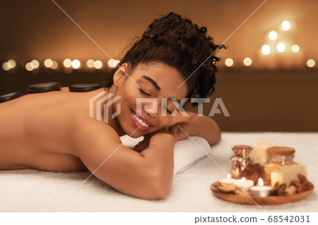 Closeup of african happy woman enjoying hot stone procedure 68542031