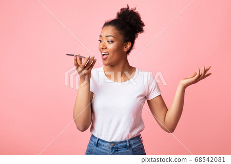 Happy afro lady using voice assistant on smart phone Happy afro lady using voice assistant on smart phone 68542081