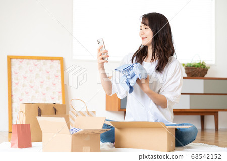 一個年輕的女人,在智能手機上打開在線購物 一個年輕的女人,在智能手機上打開在線購物 68542152