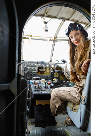 Beautiful young woman in a helmet and pilot's suit 68542276