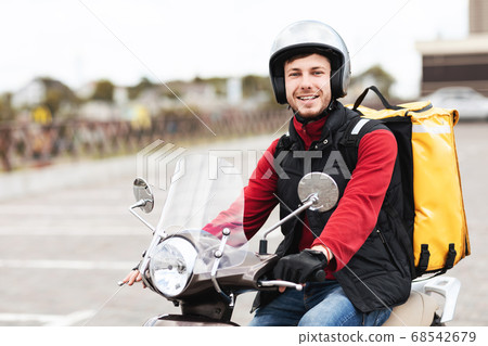 Cheerful Courier Sitting On Scooter Bike Posing Outside In City 68542679