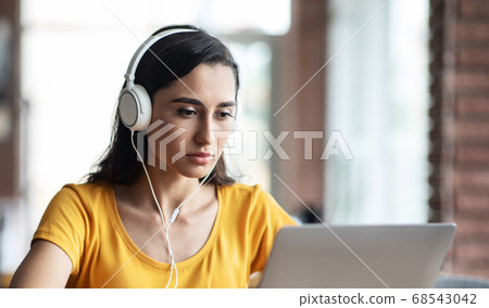 Closeup of serious arab girl looking at laptop screen Closeup of serious arab girl looking at laptop screen 68543042