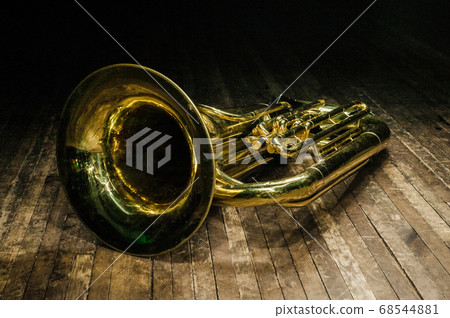 golden brass instrument tuba lies on a brown 68544881