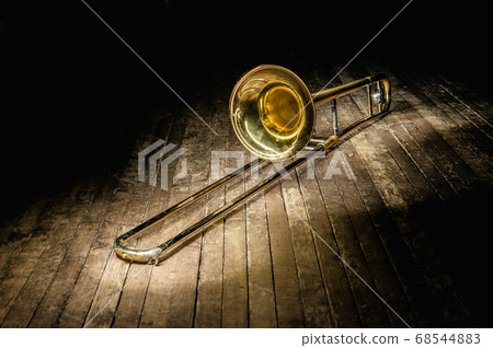 golden brass instrument trombone lies on a dark 68544883