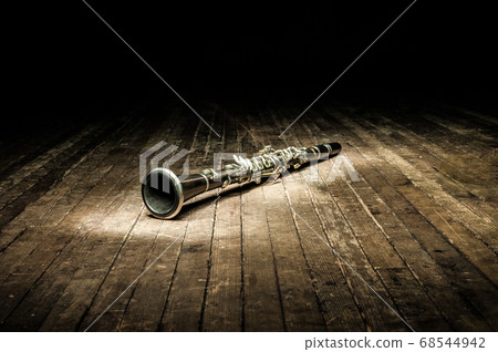 a black woodwind clarinet lies on a dark brown 68544942