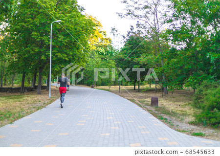 Young man doing sports and jogging in a park in the morning. Health and fitness outdoor concept. Young man doing sports and jogging in a park in the morning. Health and fitness outdoor concept. 68545633