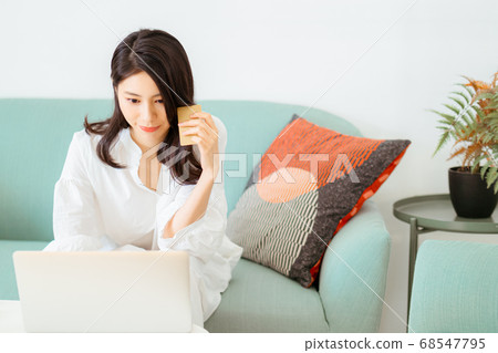 Young woman shopping online with credit card and laptop at home Young woman shopping online with credit card and laptop at home 68547795