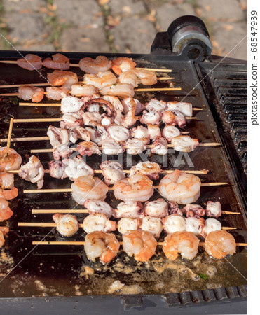 Grilling sea food, shrimps, calamari on the grill. Asia Street Food Market Grilling sea food, shrimps, calamari on the grill. Asia Street Food Market 68547939