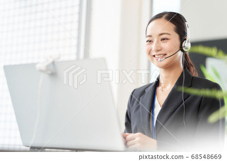 A woman making a video call to the PC 68548669