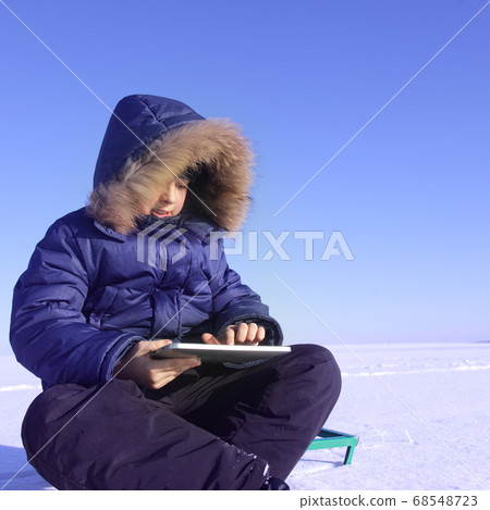 boy outdoors with tablet PC in winter  time 68548723