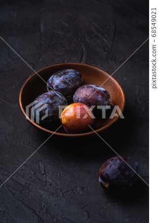Fresh sweet plum fruits in brown wooden bowl Fresh sweet plum fruits in brown wooden bowl 68549021