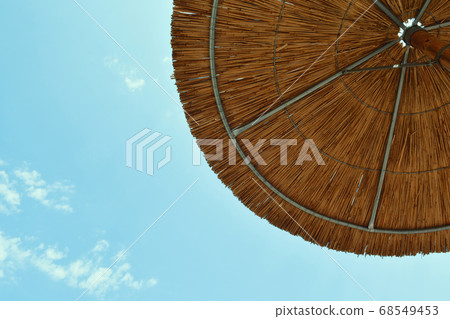 Rustic Wooden Beach Umbrella on a Clear Blue Sky 68549453