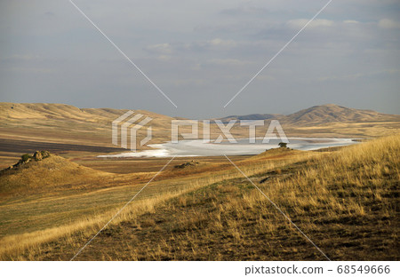 Beautiful sunny view of white desert lake with salt water among yellow fields at autumn time, south of Georgia Beautiful sunny view of white desert lake with salt water among yellow fields at autumn time, south of Georgia 68549666