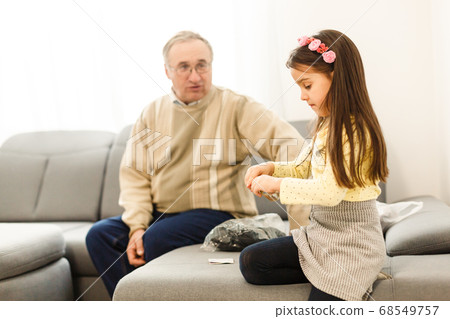 The happy girl a grandfather on the sofa 68549757