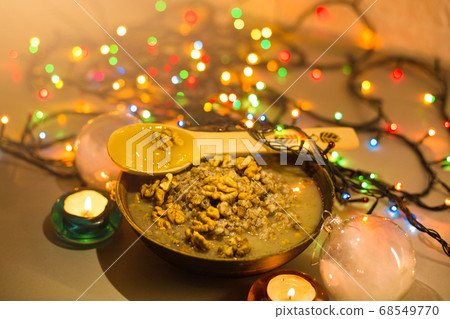 Bowl with kutia - traditional Christmas sweet meal in Ukraine, Belarus and Poland, on wooden table, on bright background 68549770