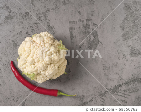 Cauliflower and red chili pepper on gray background. Cauliflower and red chili pepper on gray background. 68550762