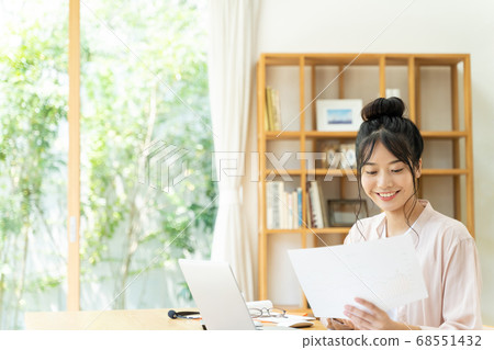 A young woman teleworking in the living room A young woman teleworking in the living room 68551432