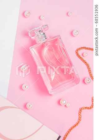 pink perfume bottle with pearls and a gold chain and a box on a pink sheet on a white background copy space. top view pink perfume bottle with pearls and a gold chain and a box on a pink sheet on a white background copy space. top view 68551936