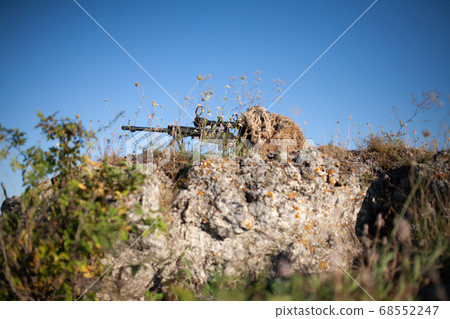 sniper in ghillie suit with precision rifle with 68552247