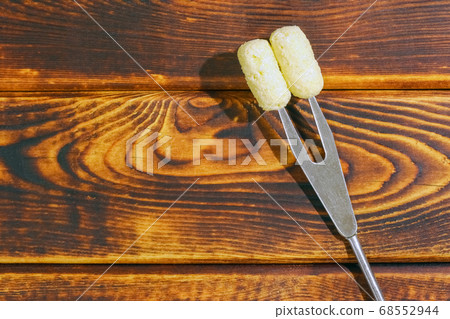 corn sticks on a fork on a wooden background corn sticks on a fork on a wooden background 68552944