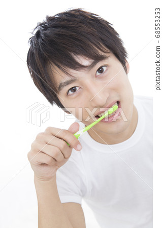 A man brushing his teeth 68553253