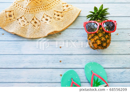 pineapple,sunglasses,watermelon,sea shell,flip flop and watermelon on wooden blue background with copy space, summer concept pineapple,sunglasses,watermelon,sea shell,flip flop and watermelon on wooden blue background with copy space, summer concept 68556209